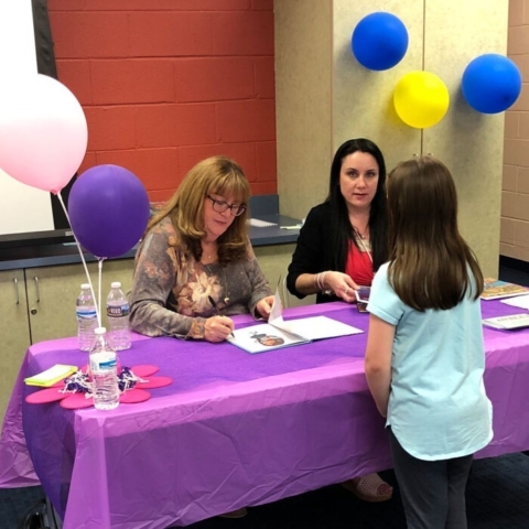 Mary signing books for children